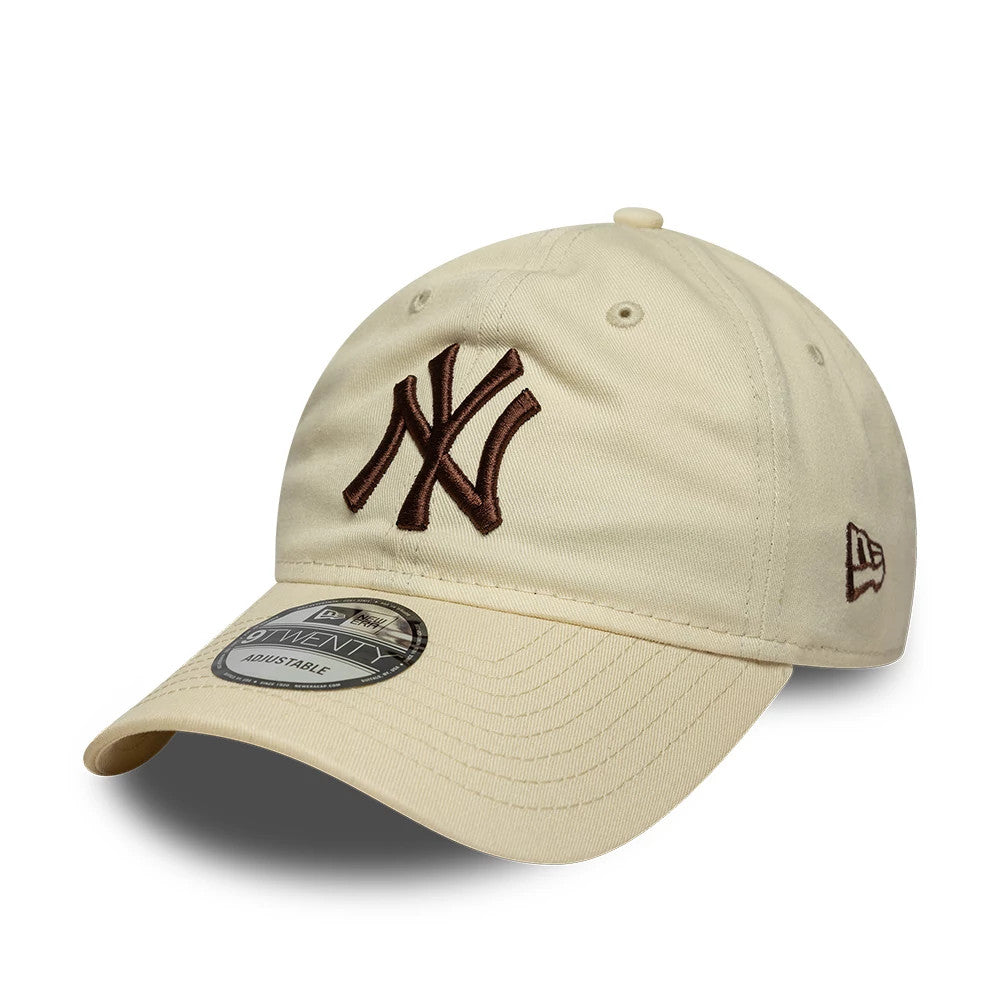New York Yankees MLB League Essential Cream New Era 9TWENTY Adjustable Cap, front view showing the raised brown embroidered NY logo on the cream crown, a curved cream visor with a 9TWENTY size sticker, and the New Era flag logo on the left side.