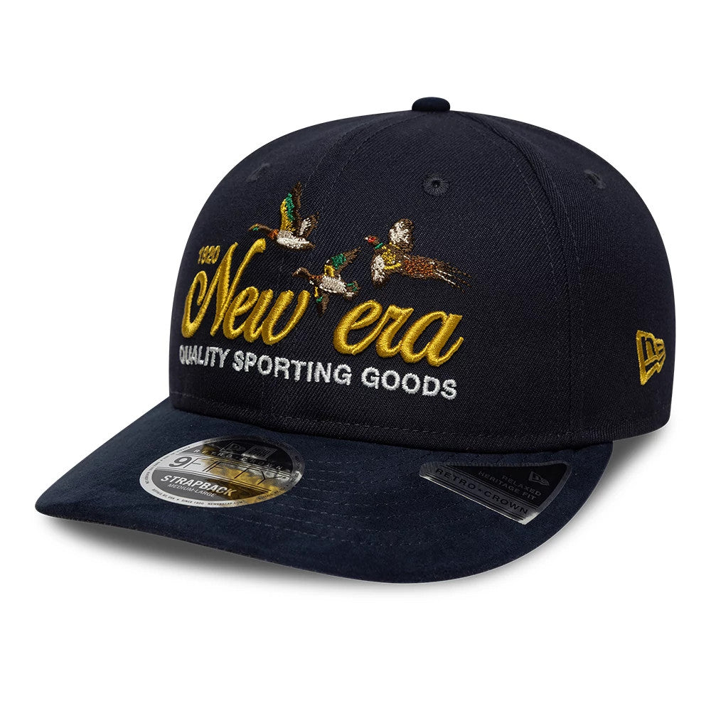 New Era Suede Navy Retro Crown 9FIFTY Adjustable Cap, three-quarter view showing yellow New Era name and duck embroidery on the front panel, with a navy suede visor and 9FIFTY size sticker, plus gold New Era flag logo on the left side.