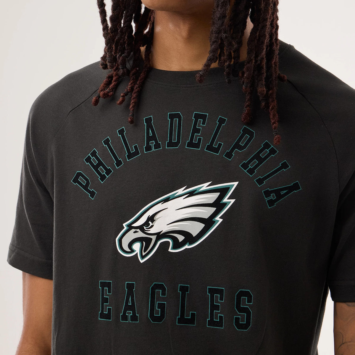 New Era Philadelphia Eagles NFL Sideline 2026 Black T-Shirt, front view on a model showing the Philadelphia Eagles printed logo in the centre of the chest, with arched Philadelphia lettering above and Eagles lettering below, both in green outline.