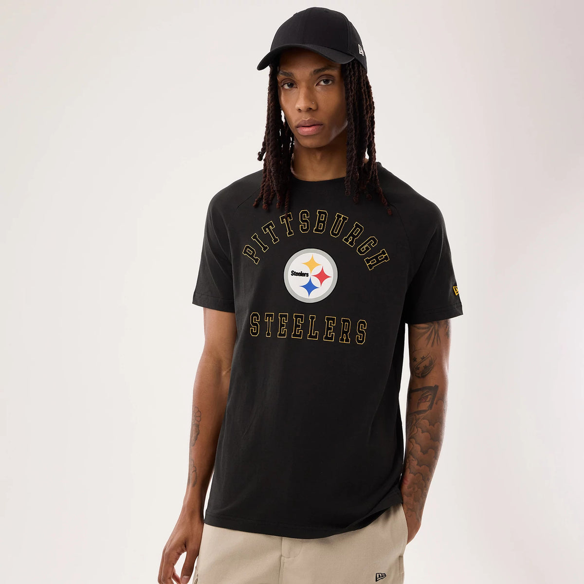 New Era Pittsburgh Steelers NFL Sideline 2026 Black T-Shirt, front view on-model showing the black t-shirt with a printed Pittsburgh Steelers logo at the centre, arched gold lettering above and below.