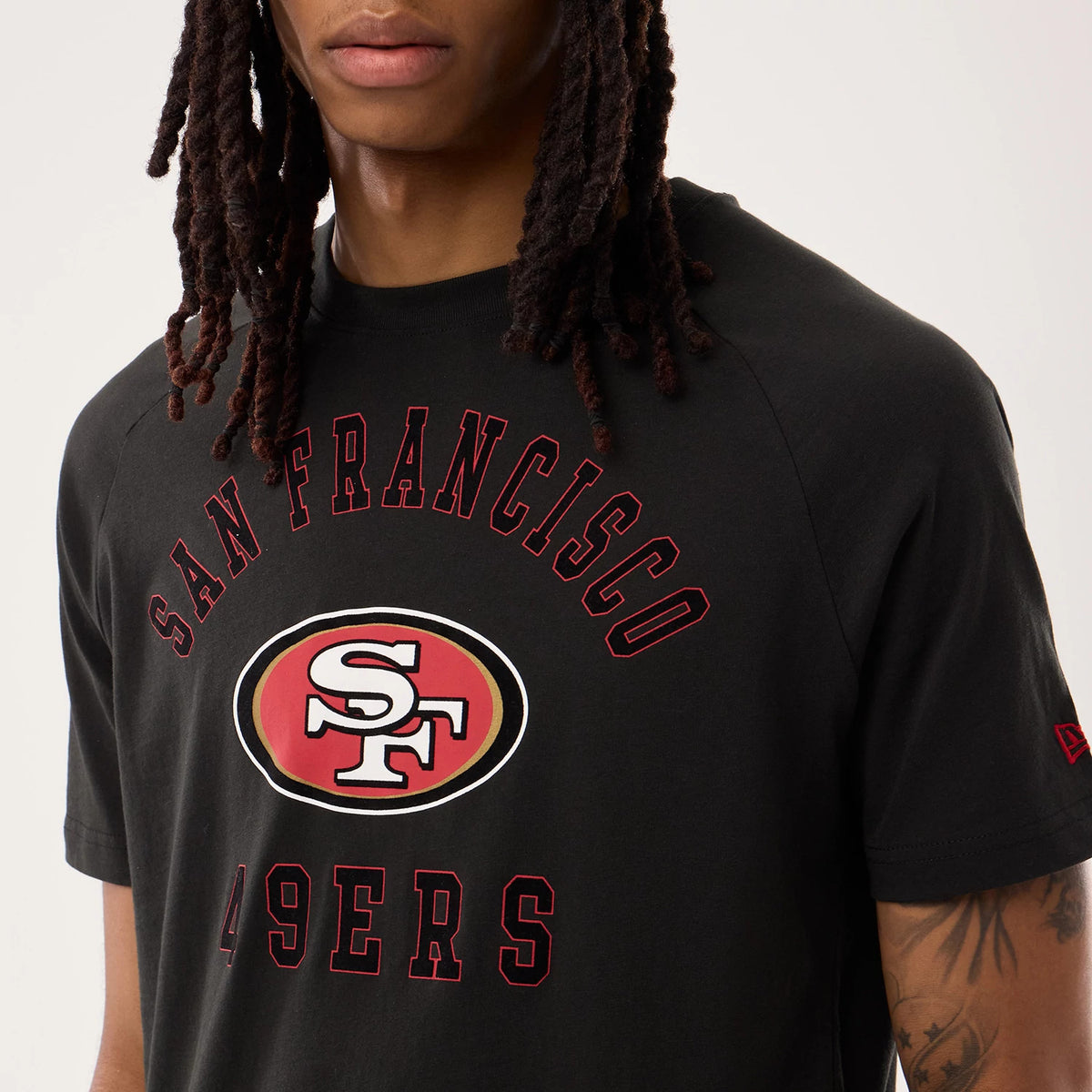New Era San Francisco 49ers NFL Sideline 2026 Black T-Shirt, front view on a model showing the large SF logo in red and white printed at the centre, with San Francisco arched above and 49ers below, and an embroidered New Era logo on the sleeve.