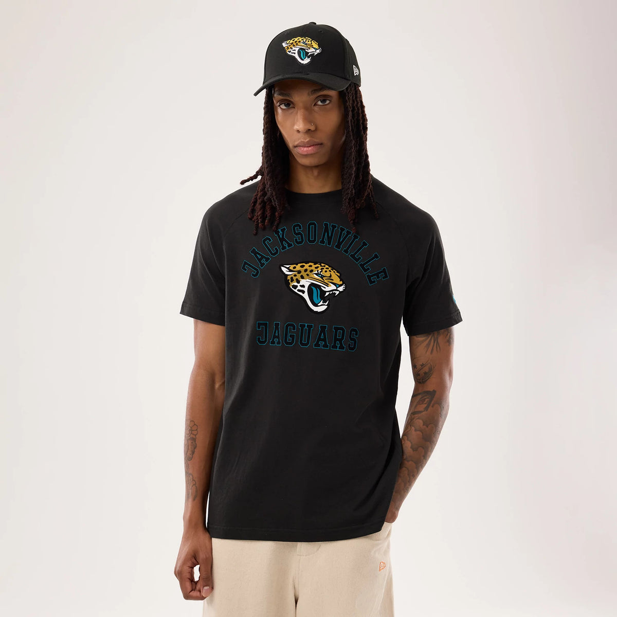 New Era Jacksonville Jaguars NFL Sideline 2026 Black T-Shirt, front view on-model displaying the team's jaguar head logo and Jacksonville Jaguars lettering in blue across the chest, with a matching cap showcasing the same logo.