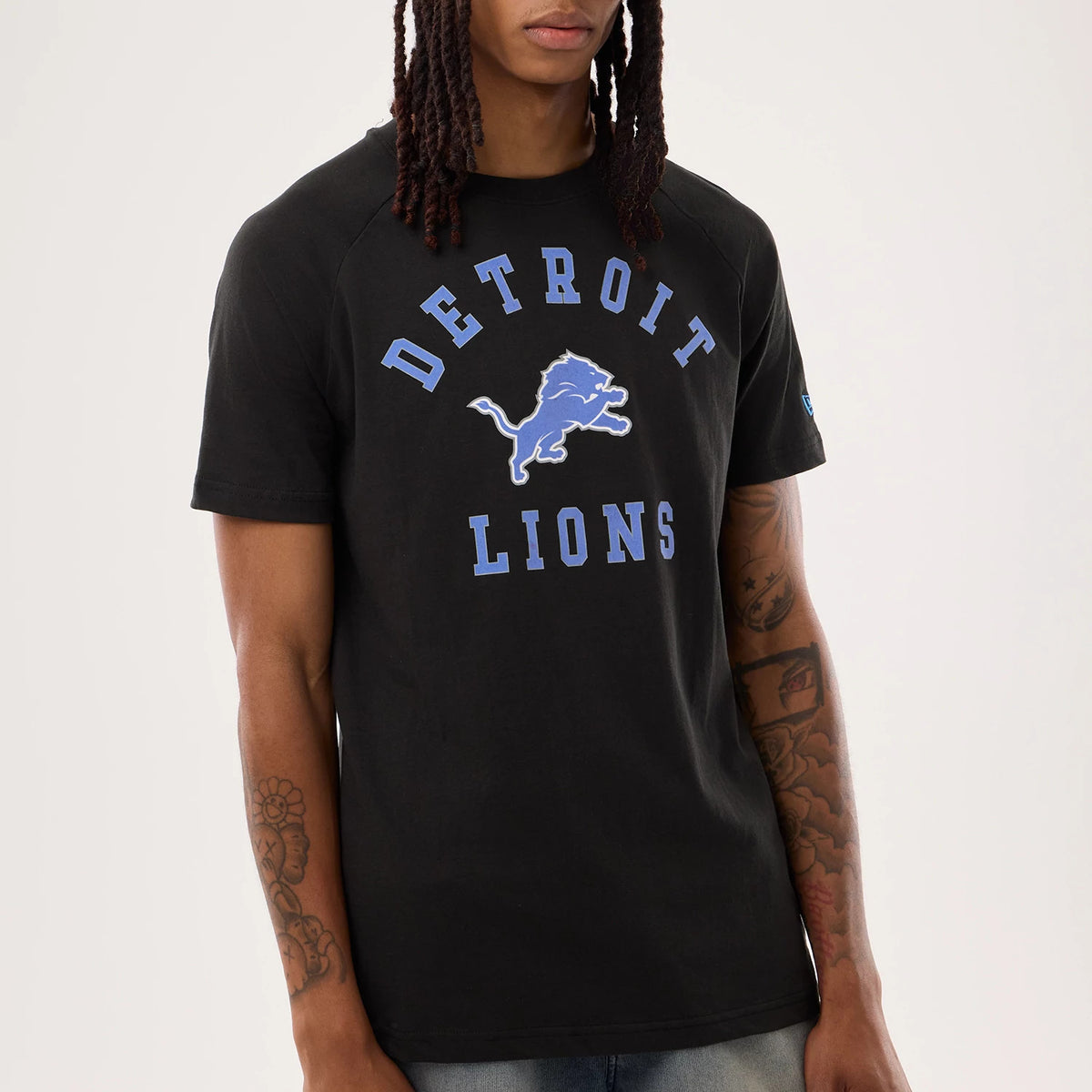New Era Detroit Lions NFL Sideline 2026 Black T-Shirt, front view on-model featuring the blue Detroit Lions logo prominently displayed in the centre of the chest, with corresponding blue lettering curved above and below the logo.