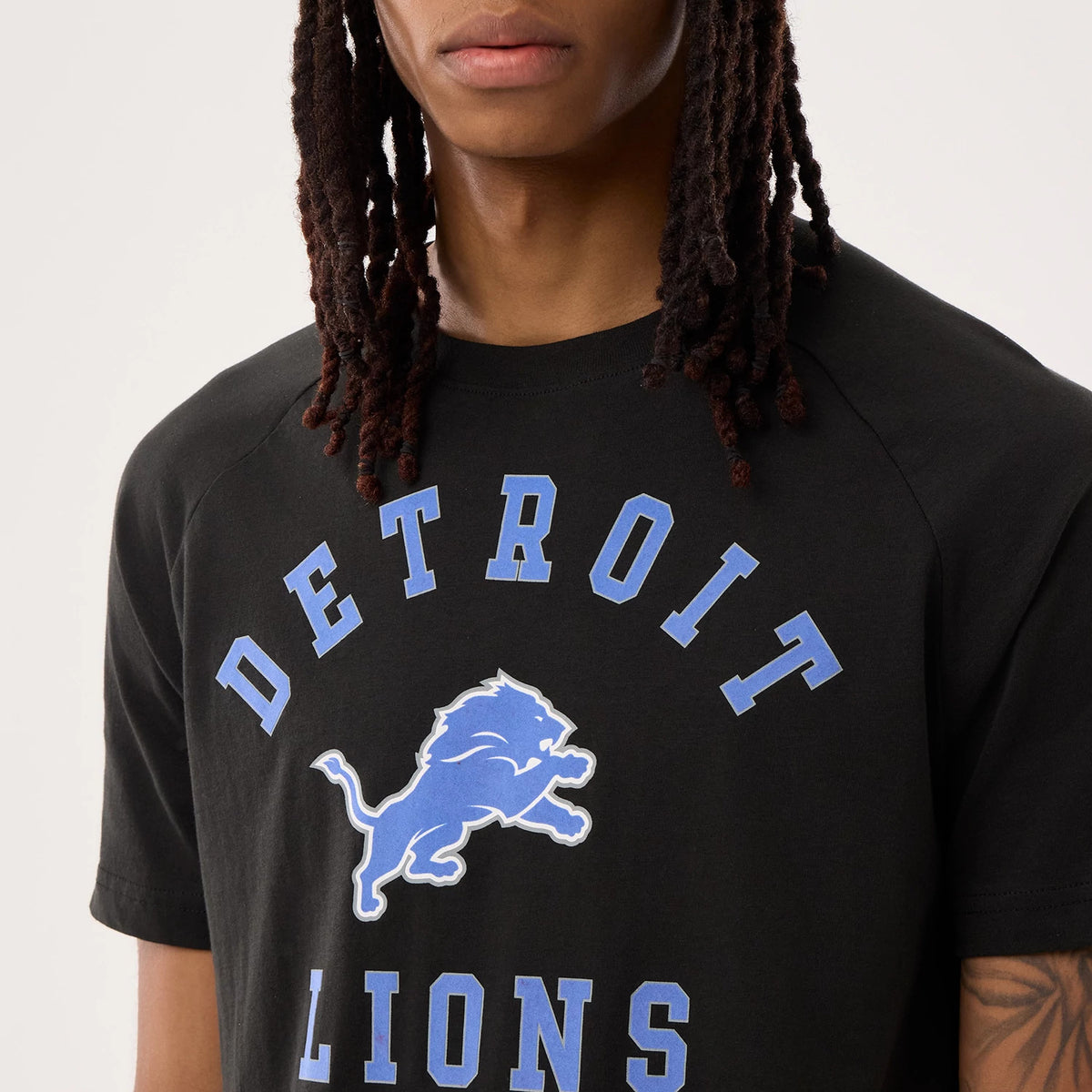 New Era Detroit Lions NFL Sideline 2026 Black T-Shirt, front view on-model showing a blue printed Detroit Lions logo centred on the chest, blue DETROIT LIONS lettering in an arch above and below the logo, and a round crew neck.