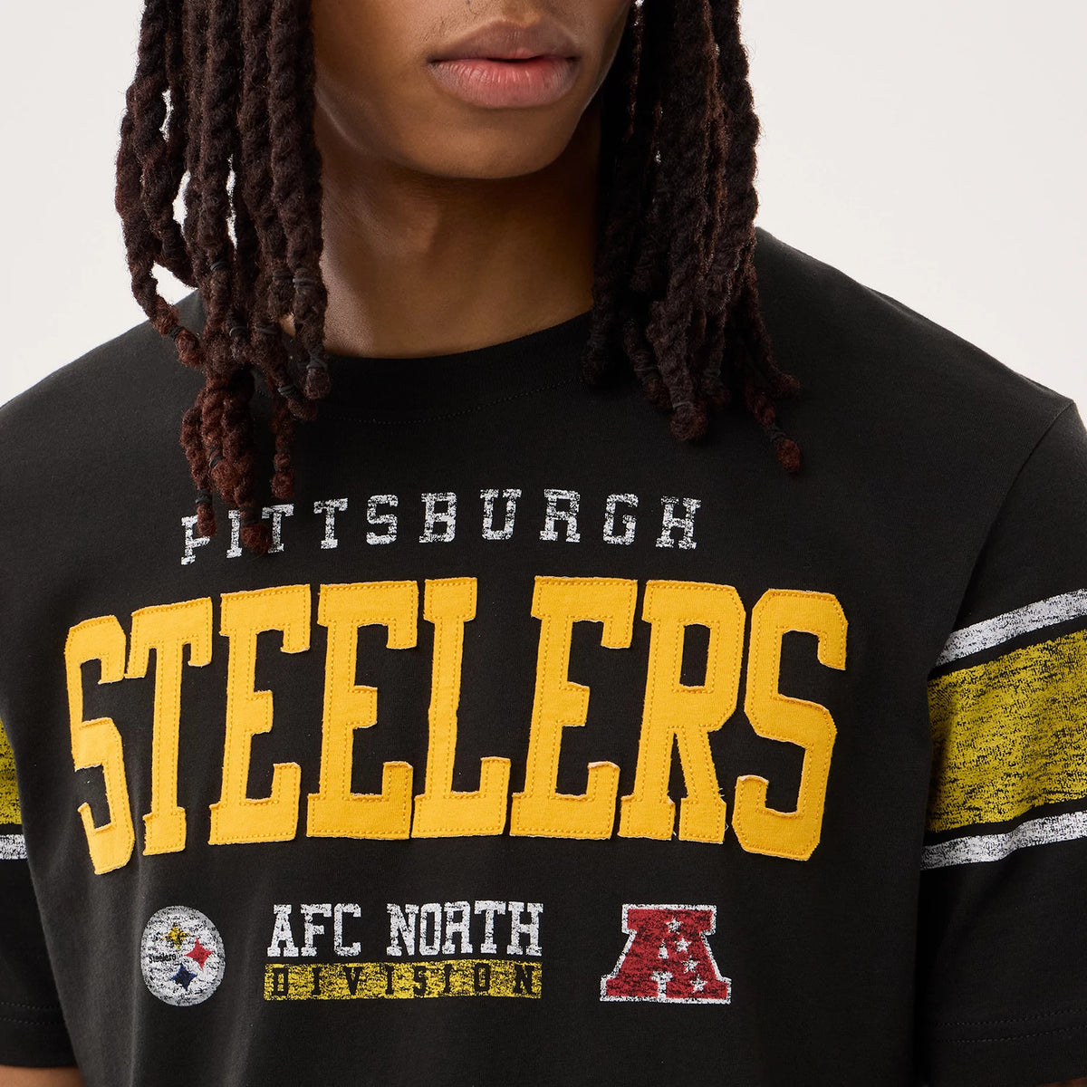 New Era Pittsburgh Steelers NFL Sideline 2026 Black T-Shirt, front view highlighting the yellow and white printed STEELERS across the chest, with additional white PITTSBURGH lettering above, and detailed AFC North Division graphics below.