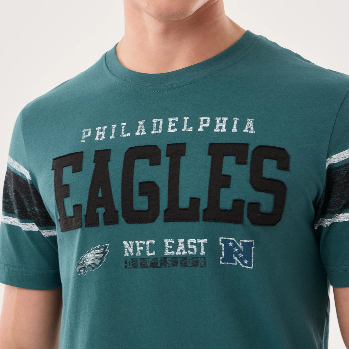New Era Philadelphia Eagles NFL Sideline 2026 Dark Green T-Shirt, front view showing embroidered Eagles lettering across the chest, with smaller printed Philadelphia, NFC East, and team logo details below, accented by striped sleeves.