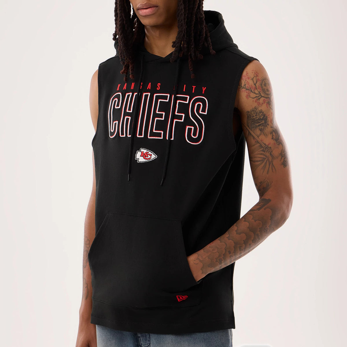 New Era Kansas City Chiefs NFL Sideline 2026 Black Tank Top, front view on a model showing the red outlined CHIEFS lettering across the chest, the Chiefs logo below, and a red New Era flag logo on the lower front hem.