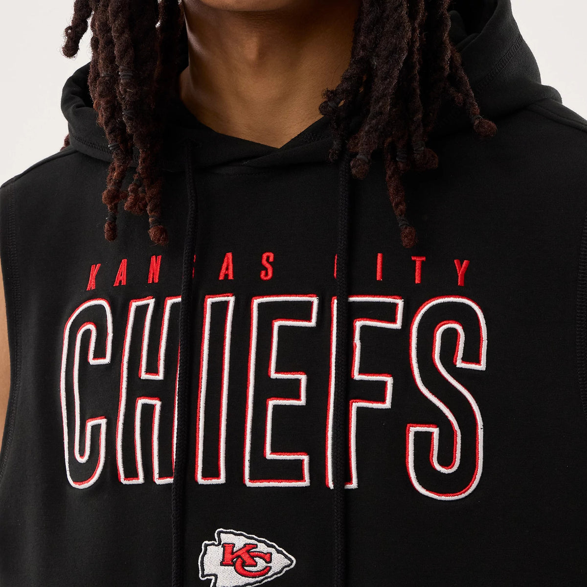 New Era Kansas City Chiefs NFL Sideline 2026 Black Tank Top, front view on a model showing large CHIEFS lettering in white with red outline across the chest and the team logo underneath, with a drawstring-adjustable black hood.