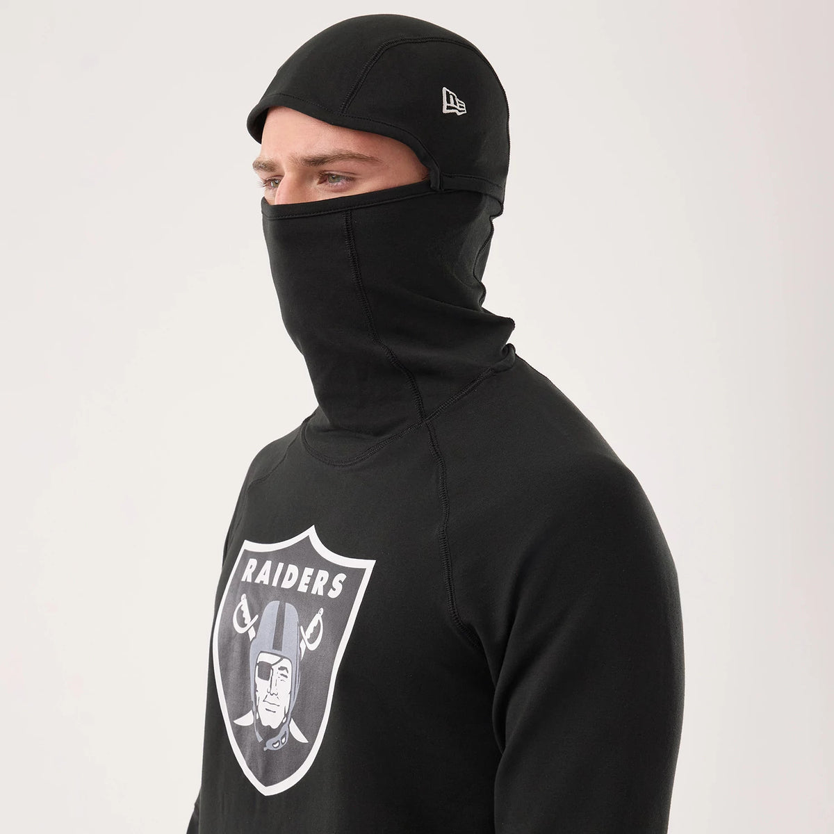 New Era Las Vegas Raiders NFL Sideline 2026 Black Balaclava Hoodie, three-quarter view showing the black balaclava-style hood covering the head and neck, white embroidered New Era logo on the side of the cap.