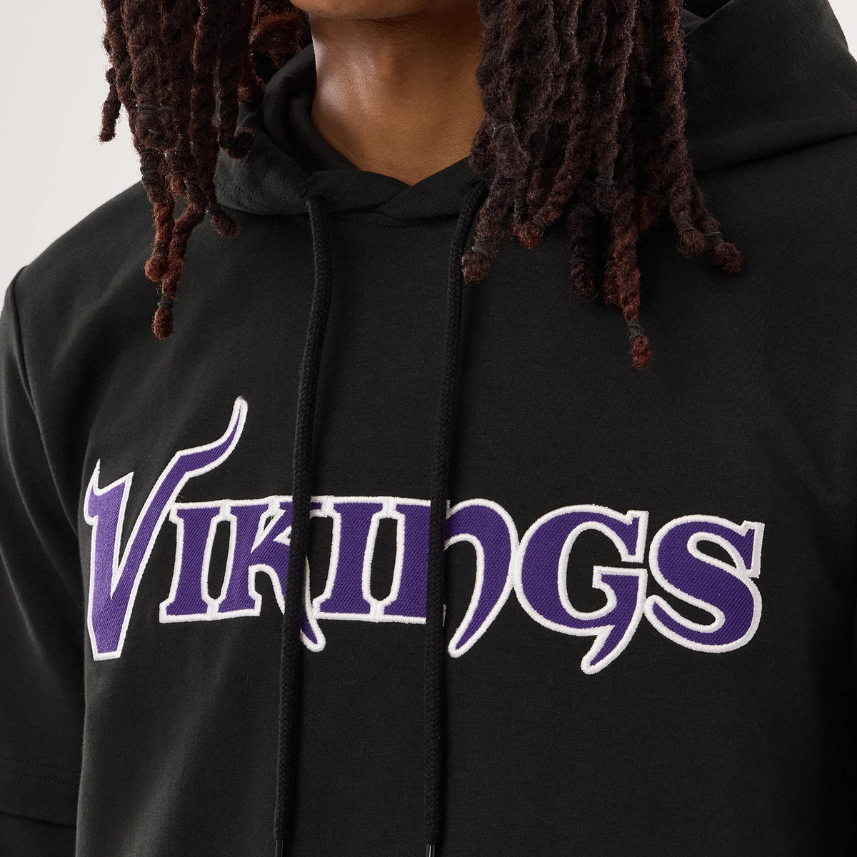 New Era Minnesota Vikings NFL Sideline 2026 Black Double Sleeve Hoodie, front view showing the purple and white embroidered Vikings lettering across the chest, with black drawstrings hanging from the hood against the solid black fabric.