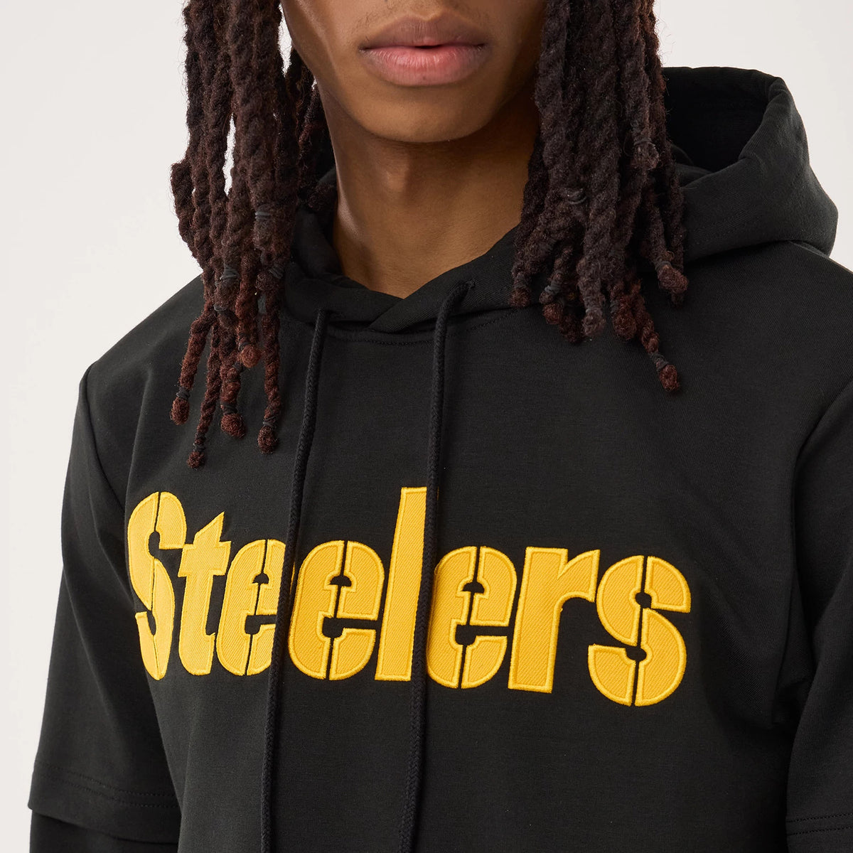 New Era Pittsburgh Steelers NFL Sideline 2026 Black Double Sleeve Hoodie, front view on-model showing a large yellow embroidered Steelers logo across the chest, a double-layered sleeve design, and the black drawstring hood offering a sporty look.