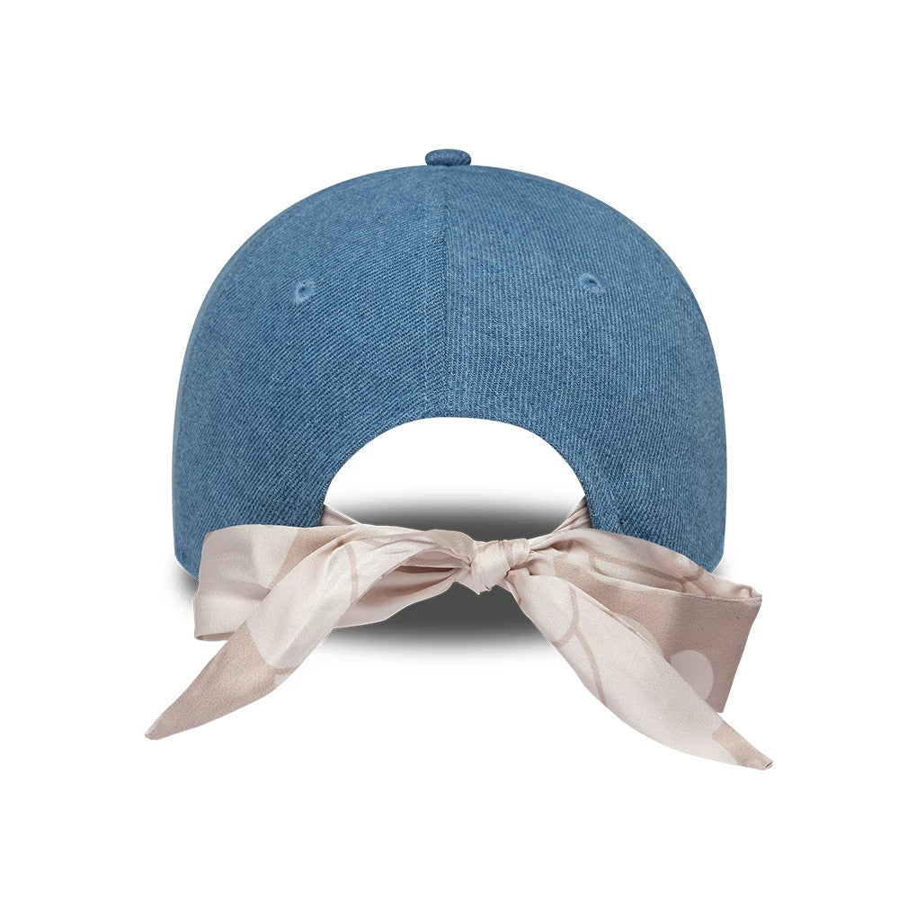 LA Dodgers Womens MLB Denim Pastel Blue New Era 9FORTY Bowback Adjustable Cap, rear view showing a large beige bow tied through the back opening, against the structured denim blue crown with embroidered eyelets.
