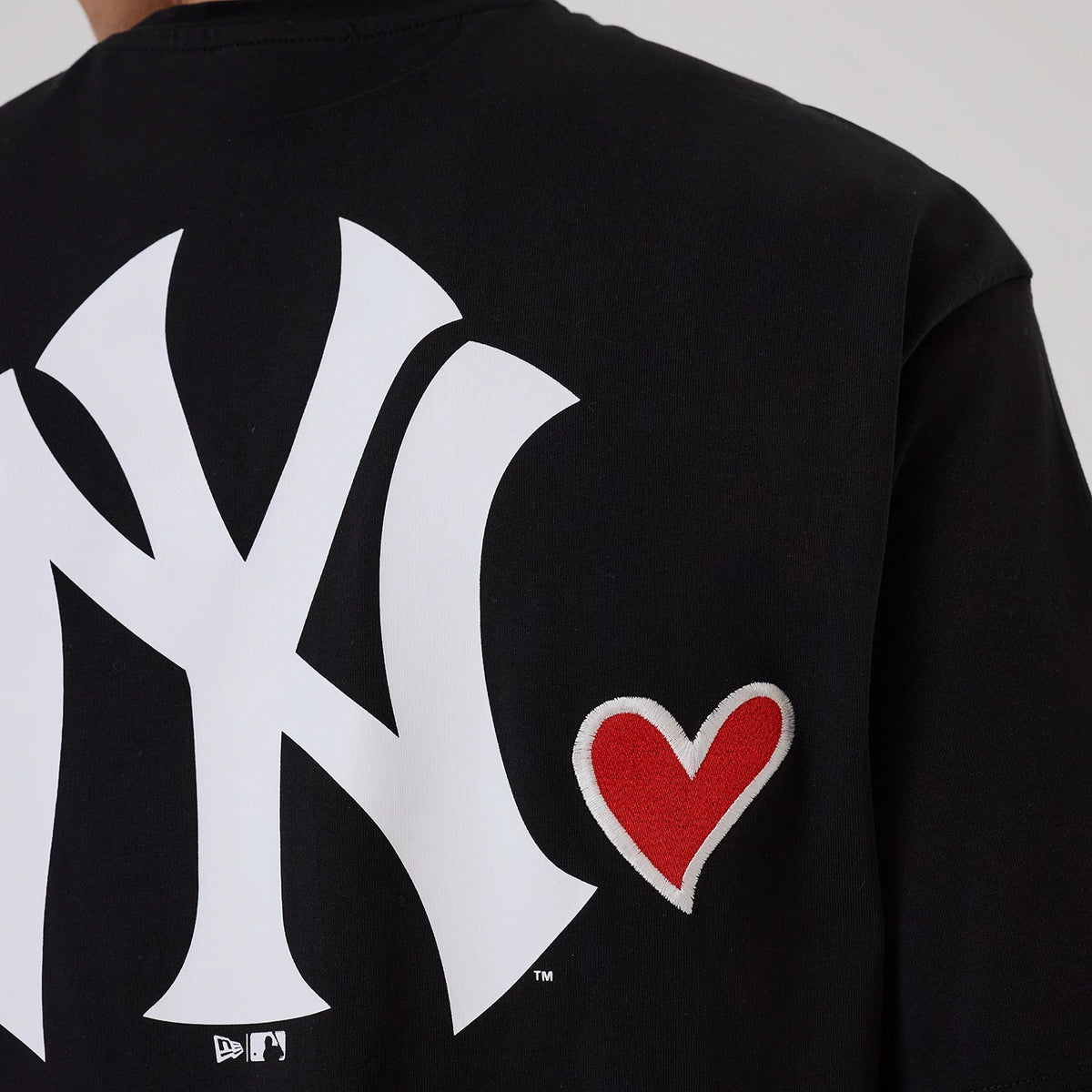 New Era New York Yankees MLB Heart Graphic Black T-Shirt, back view showcasing a large white printed New York Yankees logo and a small red heart design on the right side, with the New Era logo printed below the main graphic.