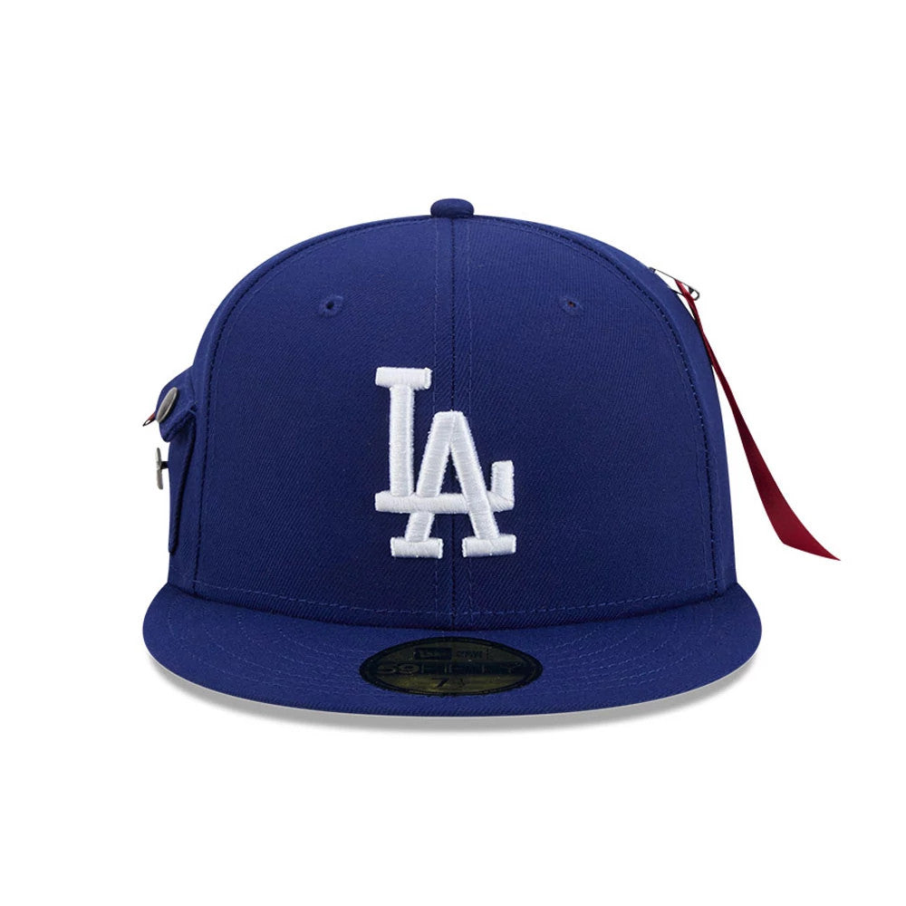 LA Dodgers MLB X Alpha Navy New Era 59FIFTY Fitted Cap, front view showing the large white embroidered LA logo on the structured navy front panels, a black 59FIFTY size sticker on the flat visor, and unique additions like a side pocket.