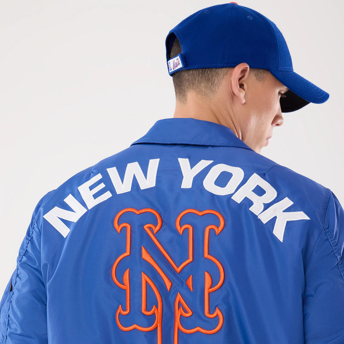 The model is wearing this MLB X Alpha New York Mets Jacket in Blue. 3