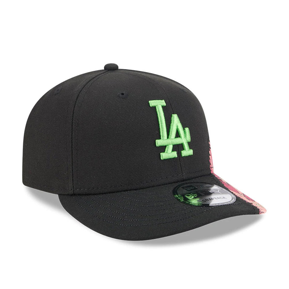 LA Dodgers MLB Halloween Black New Era 9FIFTY Snapback Adjustable Cap, three-quarter view showing a green embroidered LA logo on the front panel, with a black flat visor featuring a 9FIFTY size sticker, and a pink graphic detail on the side.