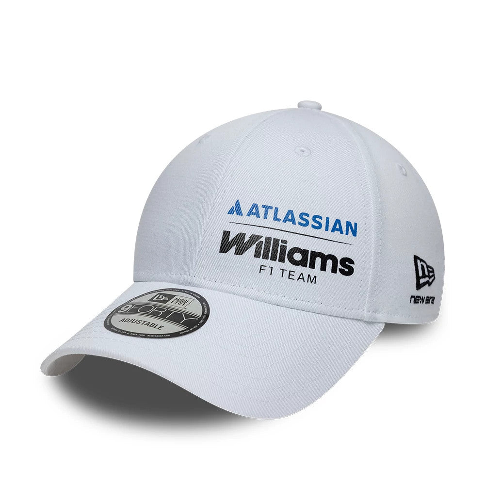 Williams Essential White New Era 9FORTY Adjustable Cap, three-quarter view showing the embroidered Atlassian logo in blue and Williams F1 Team logo in black on the front panel, with a curved white visor and 9FORTY size sticker.