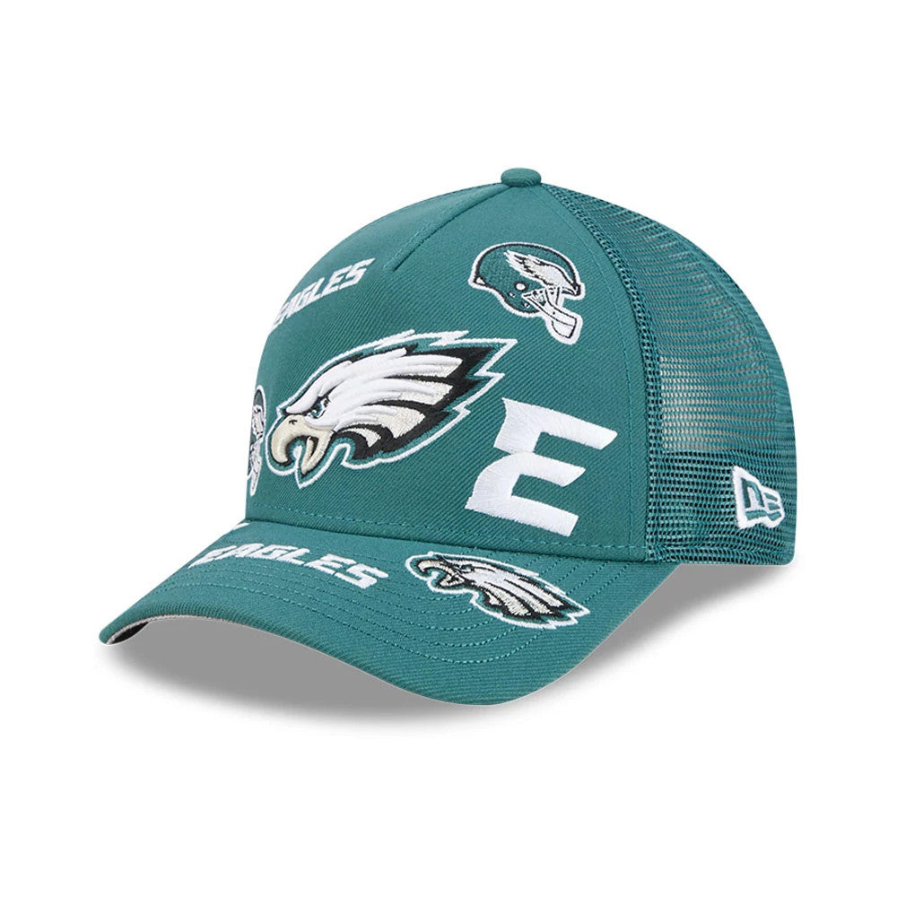 Eagles NFL All Over Dark Green New Era 9FORTY M-Crown A-Frame Trucker Adjustable Cap, three-quarter view showing the eagle logo embroidered across the front panel, surrounded by various white team graphics, with a green curved visor.