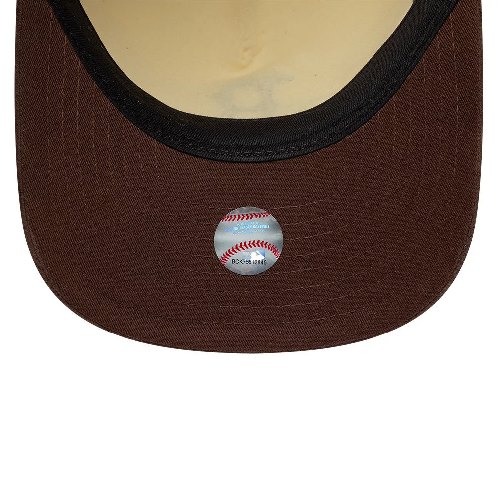 Boston Red Sox MLB Suede Visor Cream New Era 9FIFTY A-Frame Adjustable Cap, inside view showing a light brown undervisor with black edge lining and a baseball-themed sticker placed centrally, contrasting against the cream interior of the crown.