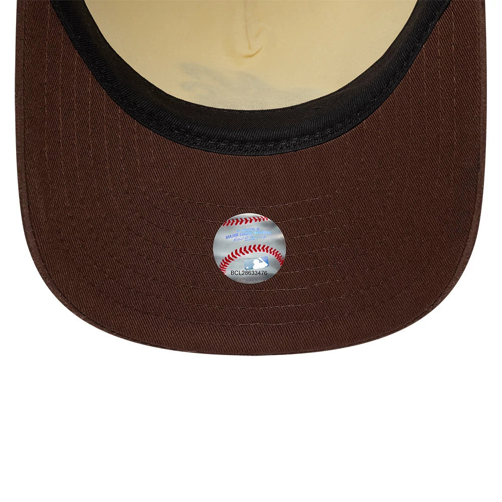 New Era Suede Visor Cream 9FIFTY A-Frame Adjustable Cap, inside view showing a brown suede undervisor with a reflective sticker featuring a red baseball seam design and black taping lining the edge of the cream sweatband.