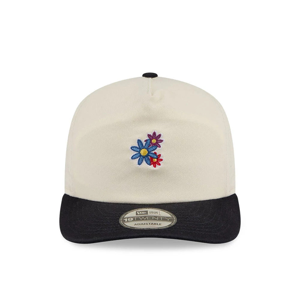 New Era Daisies Cream New Era 19TWENTY Adjustable Cap, front view showing colourful embroidered daisies on the cream front panel, a contrasting black curved visor with a 19TWENTY size sticker, and a matching black top button.