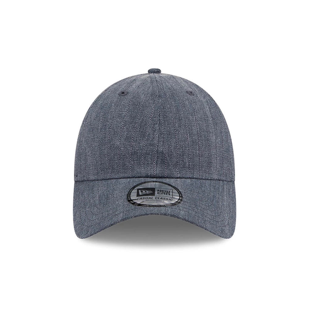 New Era Herringbone Pinstripe Navy Casual Classic Adjustable Cap, front view showing a herringbone pattern across the structured navy crown, complemented by an adjustable curved visor with a clear Casual Classic size sticker centrally placed.