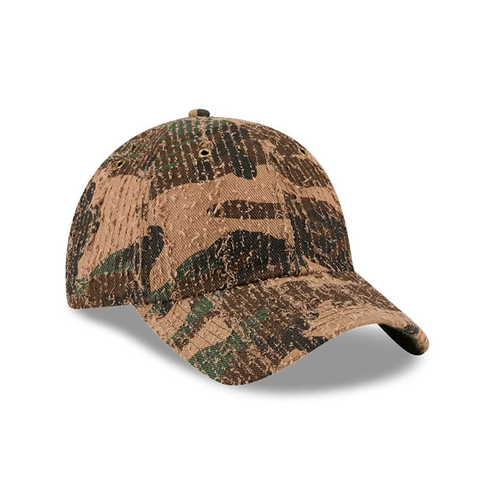 New Era Camo Casual Classic Adjustable Cap, three-quarter view showing the distinctive green and brown camouflage pattern, curved visor with textured fabric, and the relaxed crown featuring stitched eyelets for added detail.