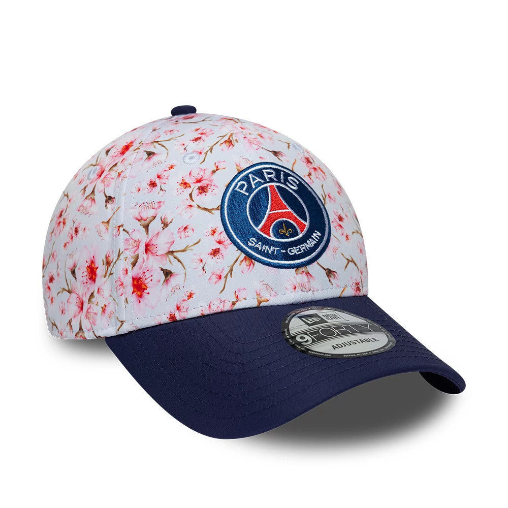 Paris Saint-Germain Cherry Blossom Navy New Era 9FORTY Adjustable Cap, three-quarter view showing the embroidered Paris Saint-Germain patch on the front panel with a cherry blossom pattern, navy curved visor and 9FORTY size sticker on top.