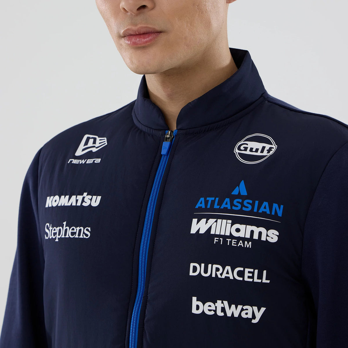 New Era Williams Navy Hybrid Jacket, front view on-model displaying a zip closure down the centre, with multiple logos including New Era printed on the left shoulder, Gulf on the right chest, and Williams F1 Team across the middle chest area.