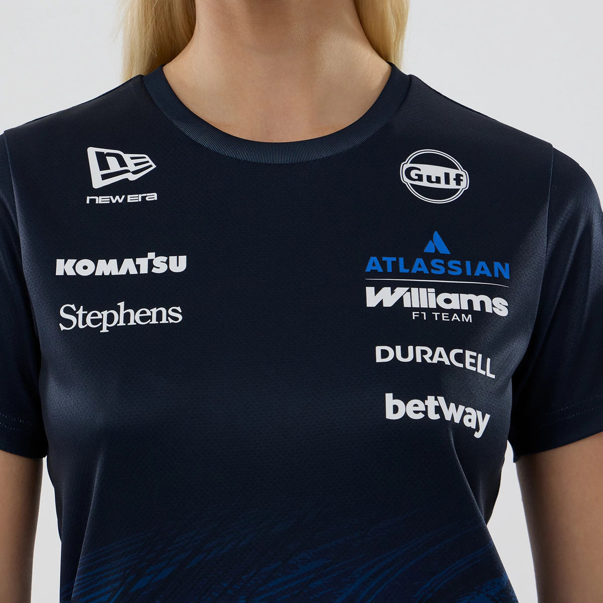 New Era Williams Womens Carlos Sainz Navy Tech T-shirt, front view on-model highlighting multiple sponsor logos including the raised New Era logo on the upper left chest, centralised Williams F1 Team logo, and contrasting Gulf logo on the right.