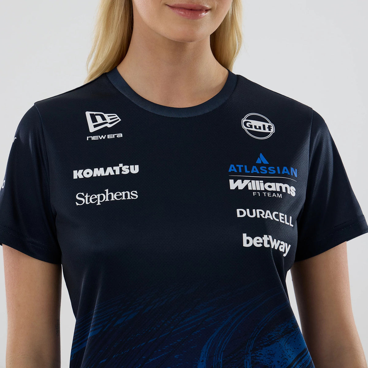 New Era Williams Womens Alex Albon Navy Tech T-shirt, front view showing a range of printed sponsor logos across the chest including New Era, Gulf, and Williams F1 Team, set on a navy background with blue abstract pattern near the hem.