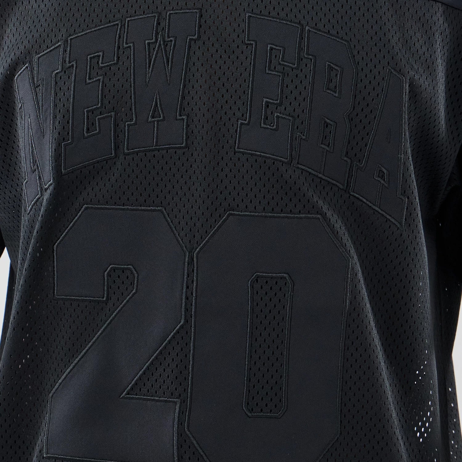 The model is wearing this New Era Mesh Oversized T-Shirt in black. 4