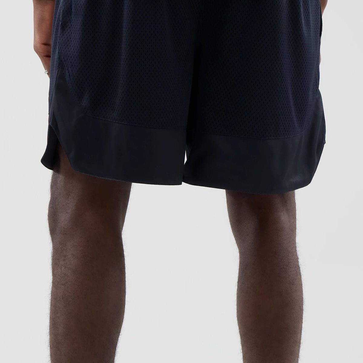 The model is wearing this New Era Mesh Oversized Shorts in navy. 7