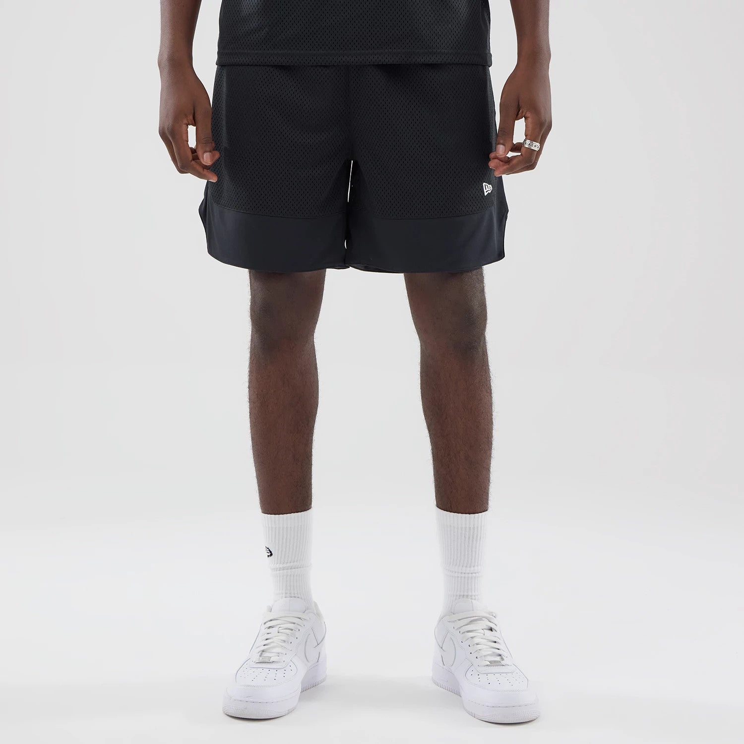 The model is wearing this New Era Mesh Stripe Oversized Shorts in black. 1