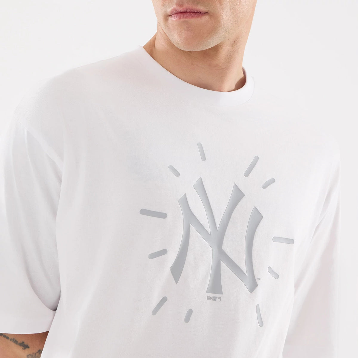 New Era New York Yankees MLB 59FIFTY Day Graphic White T-Shirt, front view on a model showing a large white reflective New York Yankees logo with surrounding rays printed centrally on the chest, short sleeves and a plain crew neck collar.