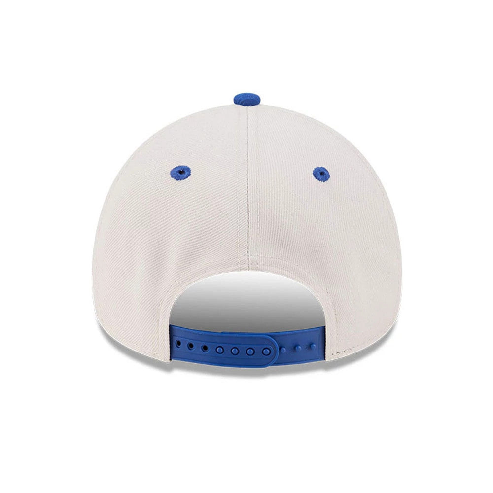 Knicks NBA Hardwood Classic Light Beige New Era 9FORTY A-Frame Adjustable Cap, rear view showing a snapback closure in royal blue, with matching blue top button and embroidered eyelets on the structured light beige crown.