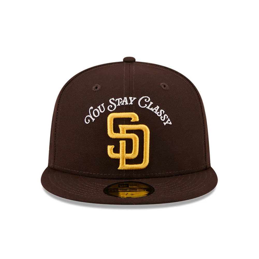 San Diego Padres MLB X Anchorman Stay Classy Black New Era 59FIFTY Fitted Cap, front view showing the gold embroidered SD logo on the front panel with a white You Stay Classy script above it, and a gold 59FIFTY size sticker on the brown visor.