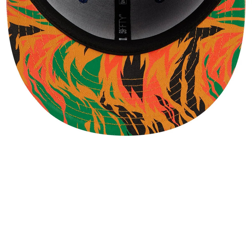 New York Mets MLB X Coming To America Blue New Era 59FIFTY Fitted Cap, inside view showing a under-visor with an abstract design in orange, black, and green, alongside a black sweatband and taping with the 59FIFTY logo.