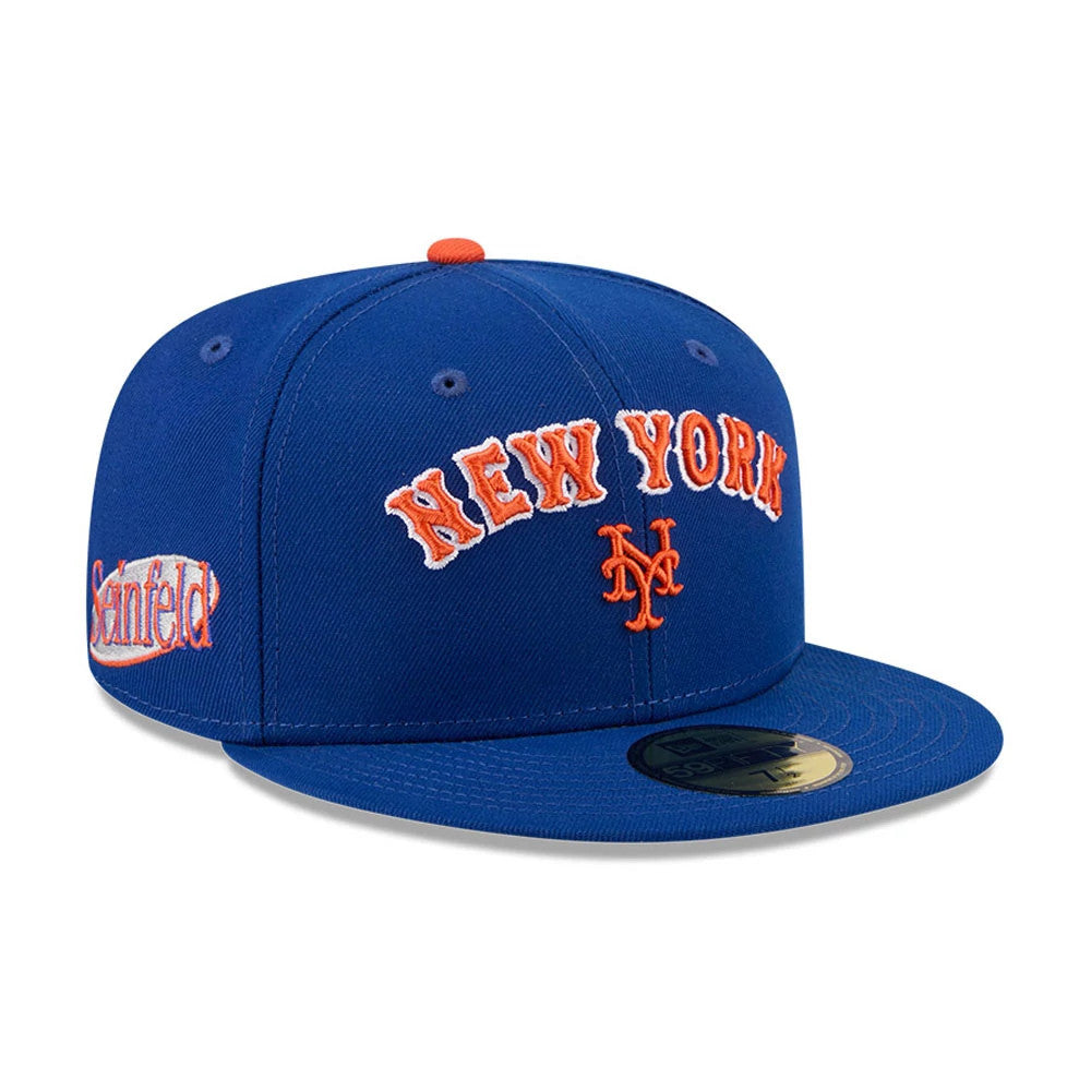 New York Mets MLB X Seinfeld Blue New Era 59FIFTY Fitted Cap, three-quarter view showing the raised orange New York lettering and NY logo on the blue front panel, with the Seinfeld logo embroidered on the left side.