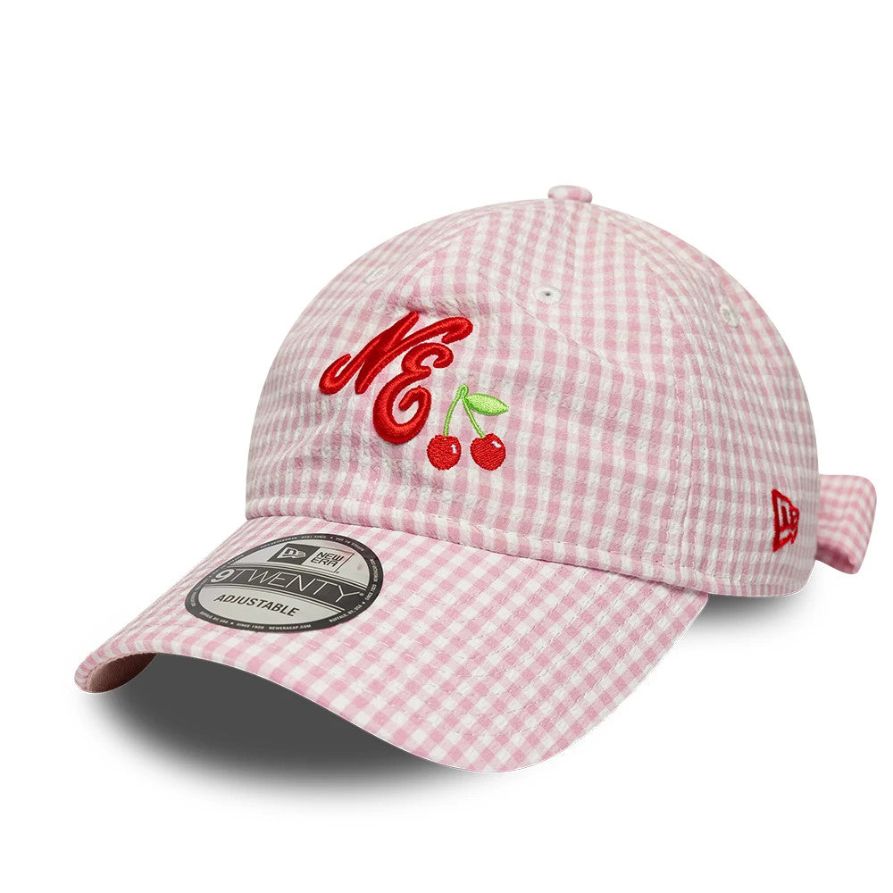 New Era Gingham Bowback Pastel Pink 9TWENTY Adjustable Cap, front view showing red embroidered NE with cherry graphic on the pink gingham checked front panel, curved visor with a 9TWENTY size sticker, and red New Era flag on the left side.