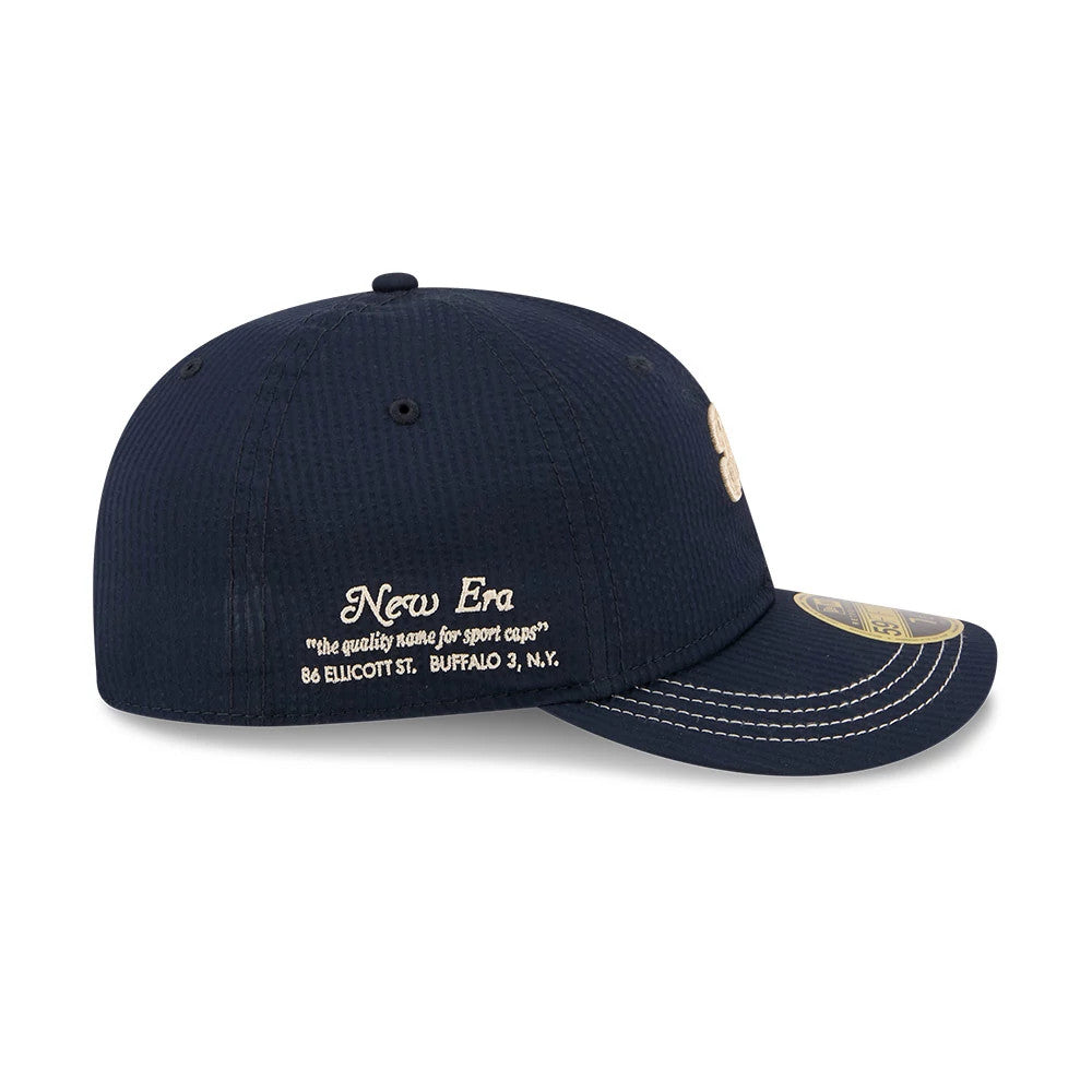 New Era 59FIFTY Day Seersucker Navy Retro Crown 59FIFTY Fitted Cap, side view showing beige New Era script and address embroidery on the rear panel, light stitching on the curved navy visor and a gold 59FIFTY size sticker on top.
