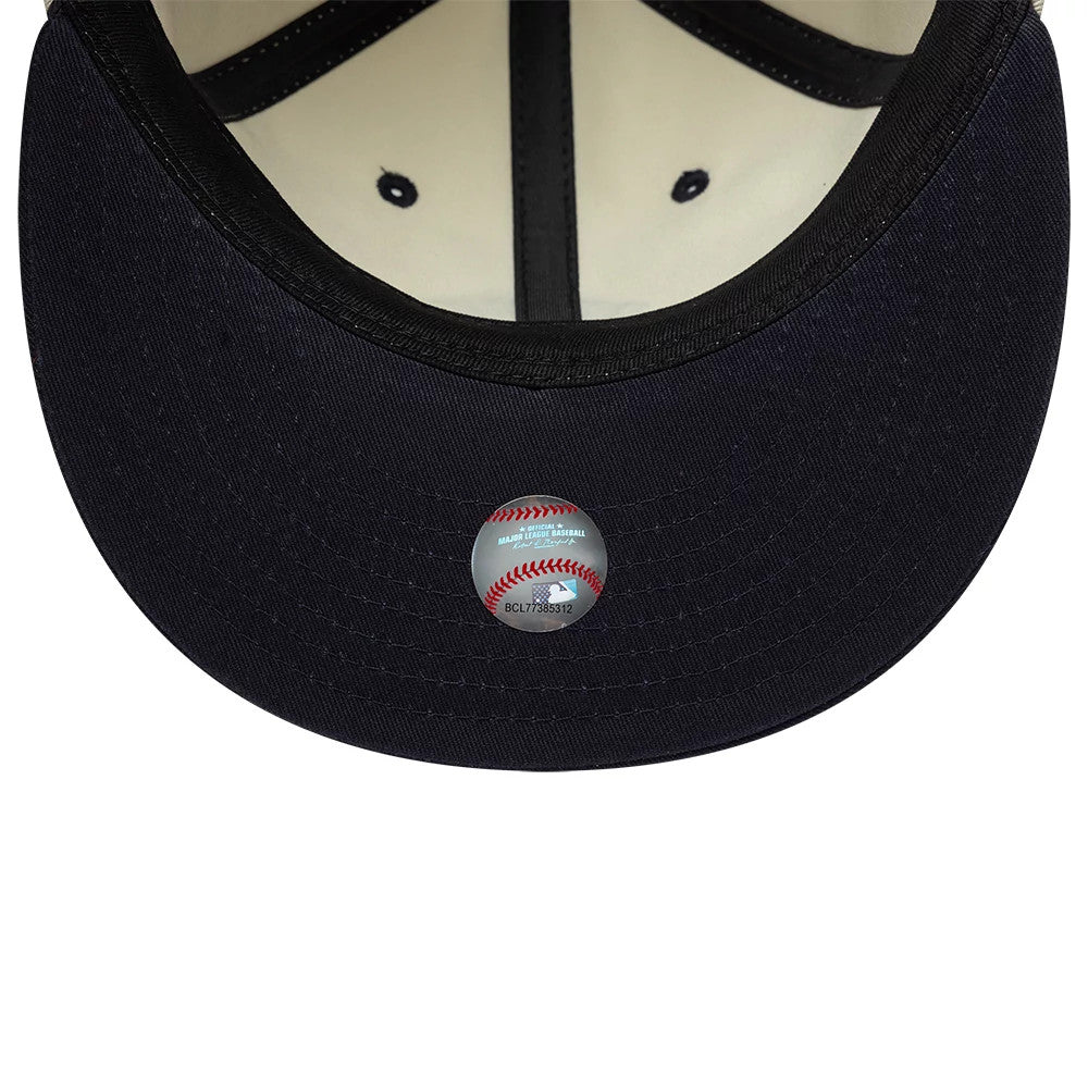 New York Yankees MLB Light Beige & Navy Retro Crown New Era 9FIFTY Adjustable Cap, inside view showing the black sweatband, white inner panels with black eyelets, and a silver sticker with a baseball graphic centred on the navy undervisor.