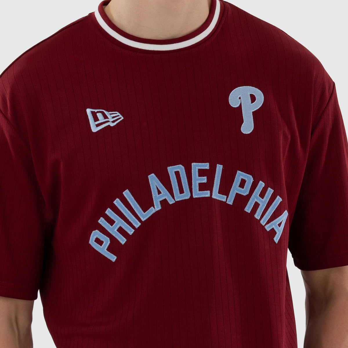New Era Philadelphia Phillies MLB Dark Red Oversized T-Shirt, front view showing large arched blue embroidered Philadelphia lettering across the chest, a white embroidered New Era logo and a grey embroidered Phillies P logo near the shoulder.