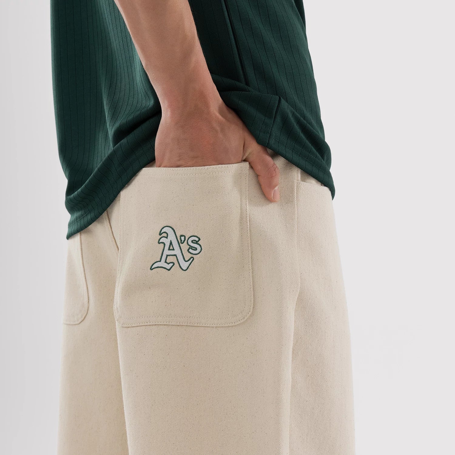 The model is wearing this MLB Jort Athletics Oversized Shorts in Cream. 3