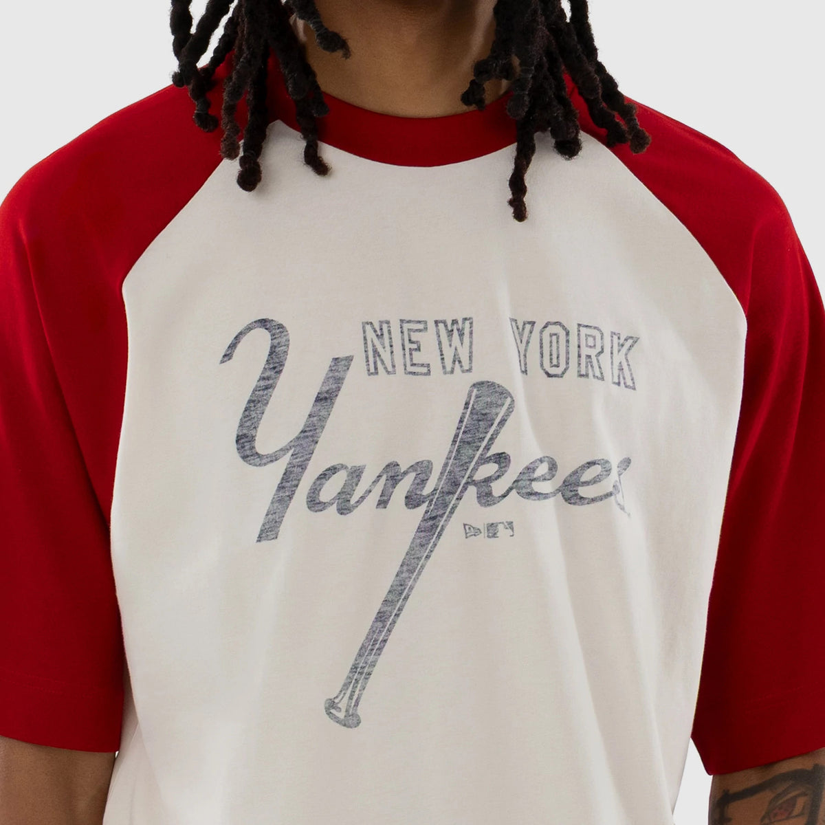 New Era New York Yankees MLB Open White Boxy T-Shirt, front view on-model showing the white body with red raglan sleeves and neckline, featuring a large printed Yankees logo with a baseball bat graphic across the chest.