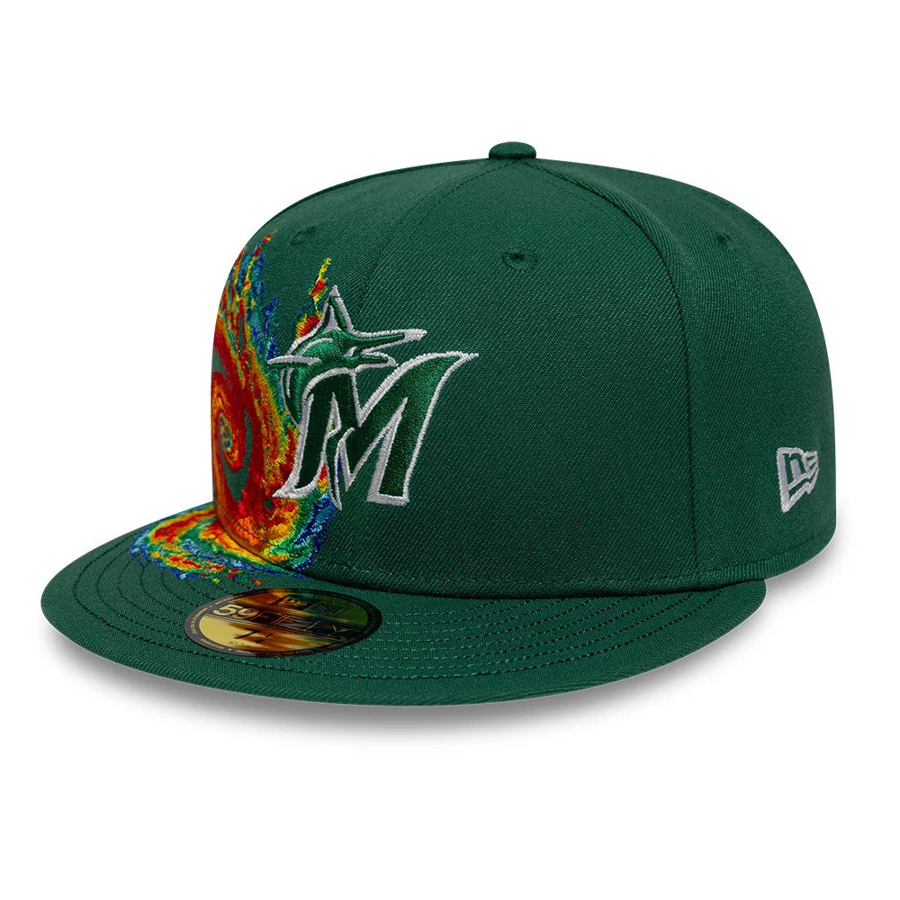 Miami Marlins MLB Storm Pattern Dark Green New Era 59FIFTY Fitted Cap, three-quarter view showing the raised white embroidered Marlins logo beside a colourful storm pattern on the front panel, green flat visor, and gold 59FIFTY size sticker.