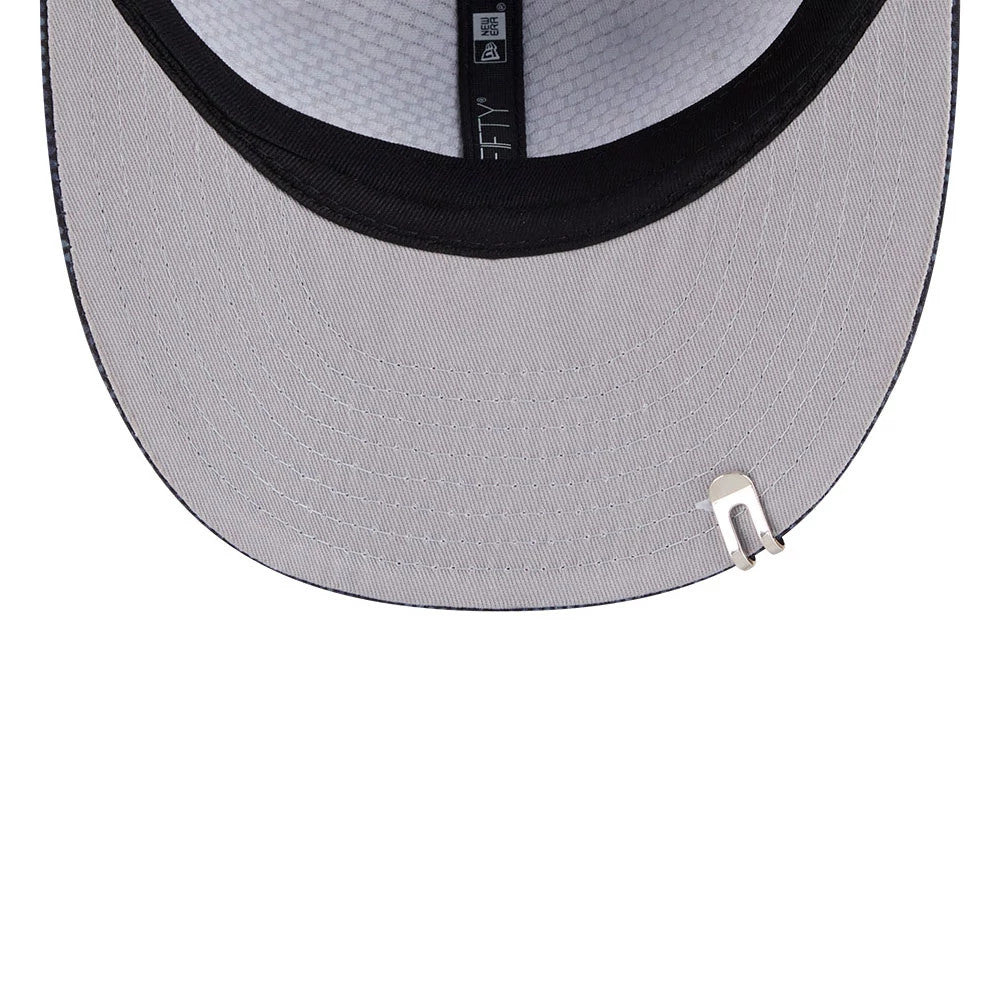 New Era Golf Black 9FIFTY Snapback Adjustable Cap, inside view showing grey undervisor with a clip attached near the visor edge, white patterned taping across the interior crown and black fabric sweatband encircling the base.