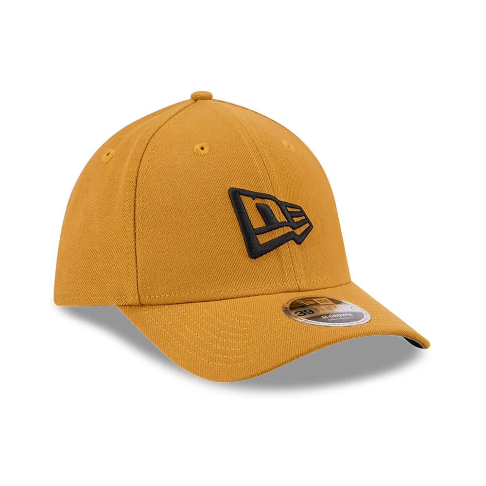 New Era Flag Gold New Era 39THIRTY M-Crown Stretch Fit Cap, three-quarter view showing a structured crown with a black embroidered New Era flag logo on the front panel, complemented by a curved visor with a 39THIRTY size sticker.