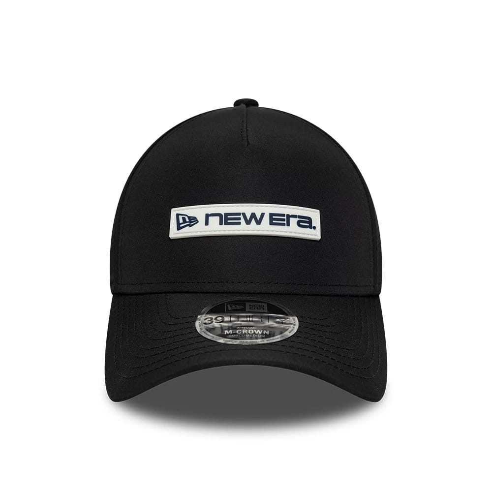 New Era Rubber Patch Black New Era 39THIRTY M-Crown A-Frame Stretch Fit Cap, front view showing a white and navy embroidered New Era logo patch on the centre panel, a curved black visor, and a 39THIRTY size sticker on the visor.
