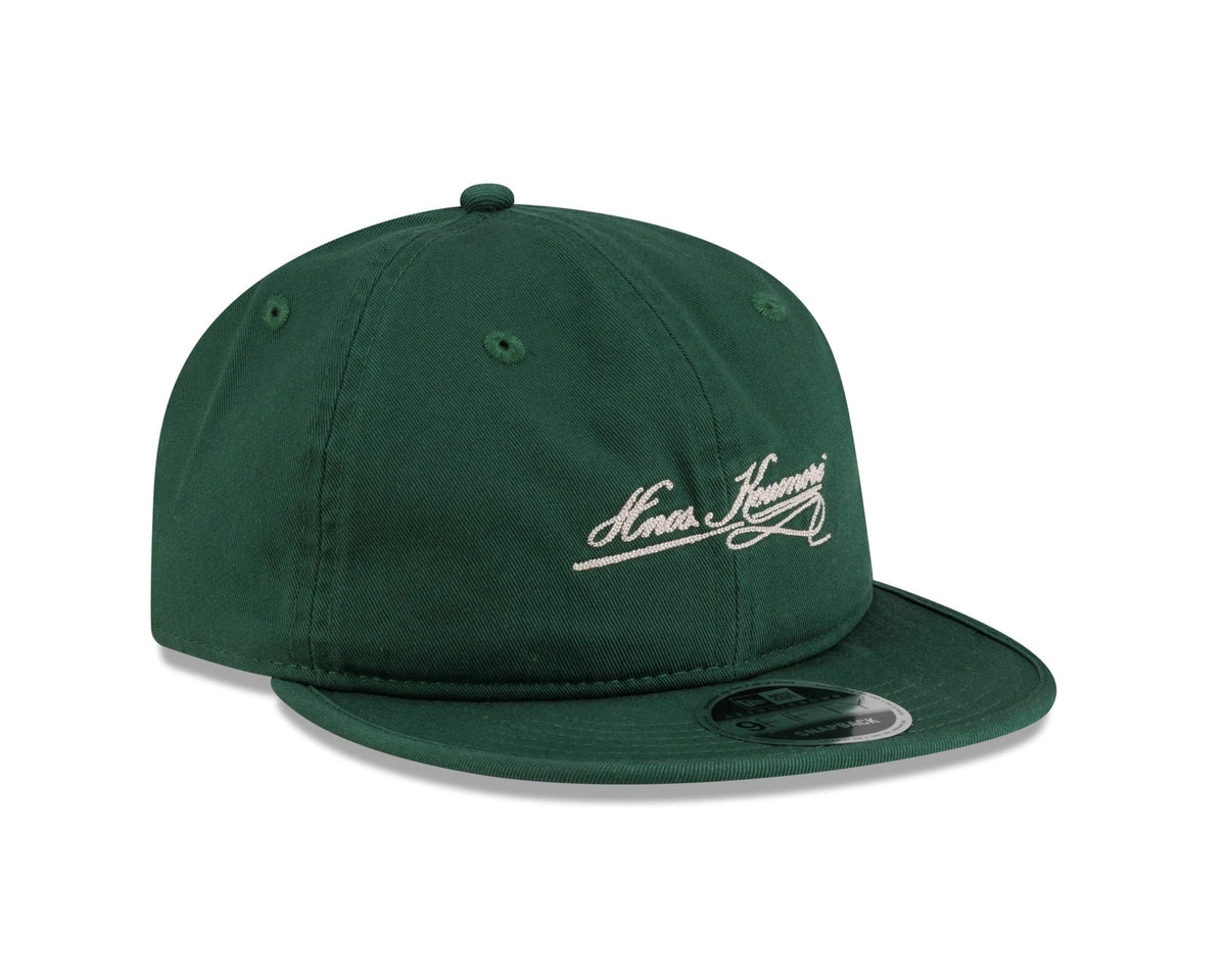 New Era X Hermanos Koumori Cursive Green Retro Crown 9FIFTY Adjustable Cap, three-quarter view showing the white cursive embroidery on the front panel, green curved visor with a 9FIFTY size sticker, and green top button matching the eyelets.